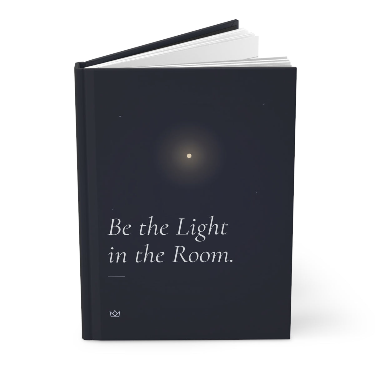 Be the Light in the Room hardcover journal standing upright with a pen on top, showing the glow on the cover and the dark spine