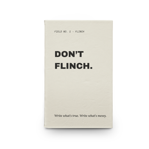 Don't Flinch bold statement vegan leather journal on a wooden table in a cozy café setting