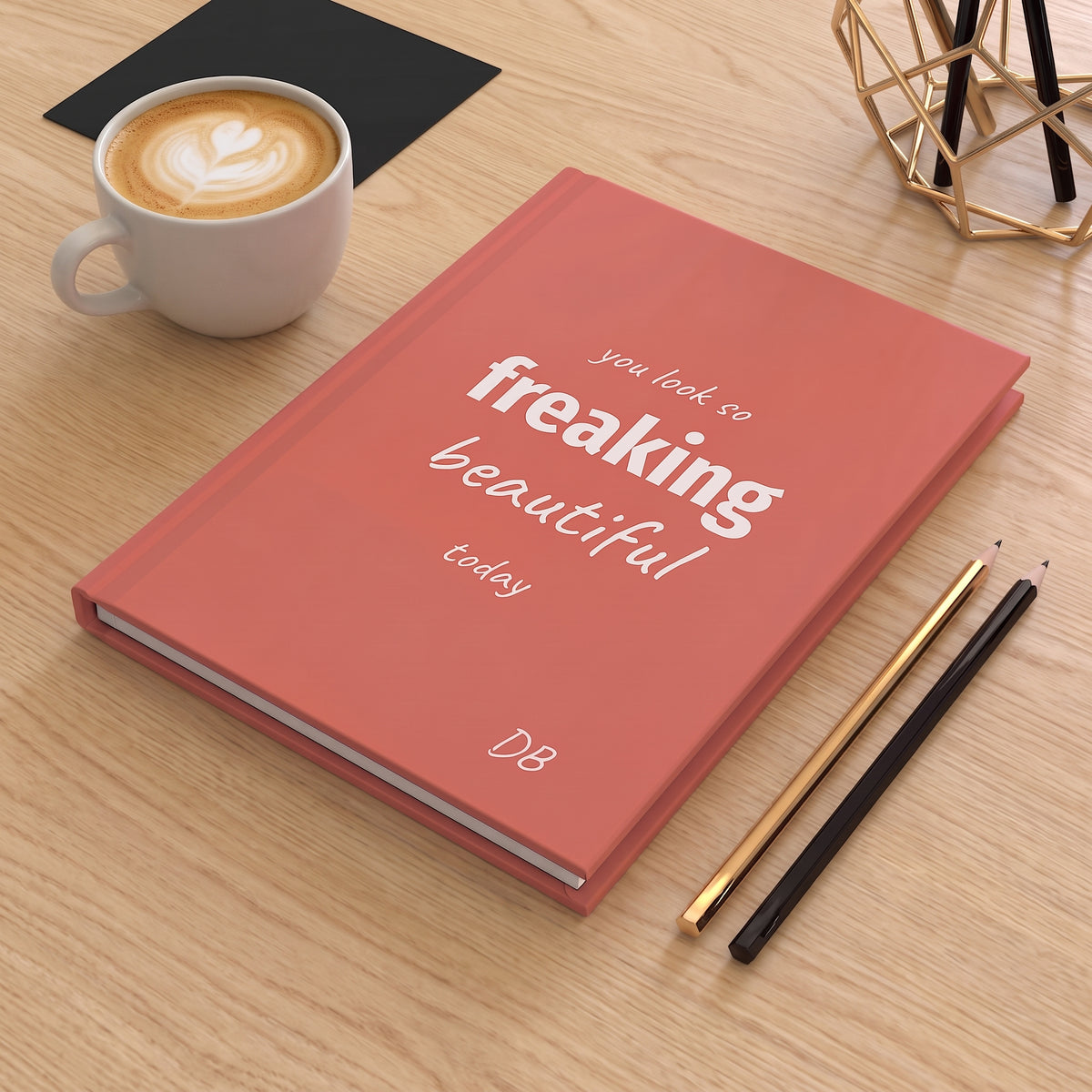 Coral Freaking Beautiful journal on a wooden table with a cup of coffee and pencils