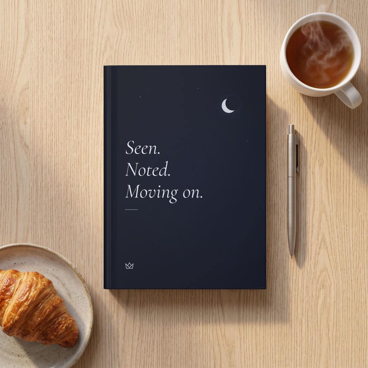 Seen. Noted. Moving on. journal on a breakfast table with a croissant, a cup of tea and a pen